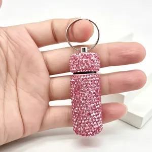 Close-up detail of a sparkly pink rhinestone keychain bottle pendant, shining crystal container.