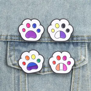 Gros plan de broches émaillées en patte de chat colorée avec des motifs de drapeau.