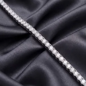 Gros plan détail d'un bracelet tennis argenté étincelant avec des pierres scintillantes sur satin.