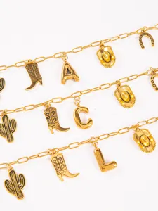 Detailed view of gold western cowboy charm necklace with boots cactus and letter pendants.