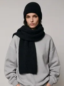 Gros plan détaillé d'un ensemble écharpe et bonnet en tricot noir, accessoire d'hiver.