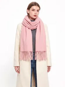 Vue de détail en gros plan de la texture douce et épaisse de l'écharpe rose à franges.