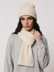 Gros plan détaillé du bonnet en tricot beige et de l'ensemble d'écharpe, texture douce.