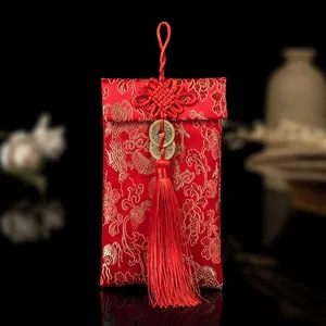 Traditioneller chinesischer Brokat-Geldbeutel mit goldenem Blumenmuster und Quaste für Hochzeit.