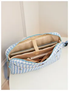 Blue white checkered laptop bag detail view with multiple interior compartments for storage.