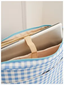 Close-up detail shot of the blue and white gingham laptop backpack interior compartment.
