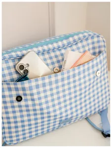 Blue and white gingham laptop backpack front pocket detail showcasing storage capacity and design.