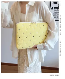 Detailed view of yellow embroidered laptop sleeve, cute dash pattern case for tablet and notebook.