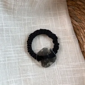 Elegante coletero de pelo elástico negro con detalle de dije cuadrado de acetato translúcido.