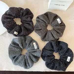 Herfst gebreide haarscrunchies detail, gezellige wollen textuur, stijlvolle paardenstaart houder.