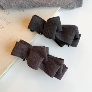 Pince à cheveux nœud à chevrons gris foncé, élégant accessoire en tissu pour coiffure quotidienne.