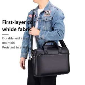 Vista dettagliata della elegante borsa da lavoro nera in pelle con tracolla e manico.