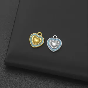 Primer plano detallado del colgante de metal en forma de corazón con estrases azules y acabado
