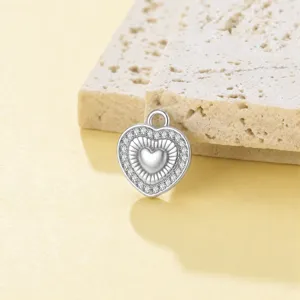Primer plano detalle colgante corazón estrás plateado, abalorio joyería DIY cristal.