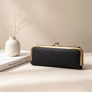 Detailed view of black leather kiss-lock storage case with retro bronze metal frame.