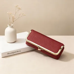 Detailed view of a red leather kiss-lock pouch, featuring premium texture and gold metal frame.