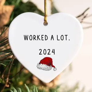 Christmas white heart shaped acrylic ornament with funny holiday quote and hanging string.