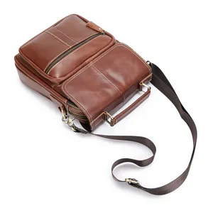 Close-up details of brown genuine leather men messenger bag with durable metal zippers.