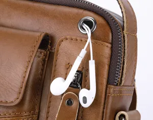 Detail view of genuine leather men's bag featuring convenient headphone cable pass-through.