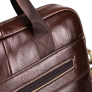 Men's leather briefcase detail shot, premium brown leather texture with sturdy handle and zipper.