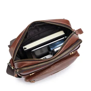 Brown leather men messenger bag detail view showing spacious interior and multiple compartments.