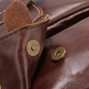 Close-up detail shot of vintage brown oil wax leather men bag showing texture and metal snap.