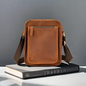 Close-up of vintage brown leather vertical men messenger bag, classic casual shoulder bag.