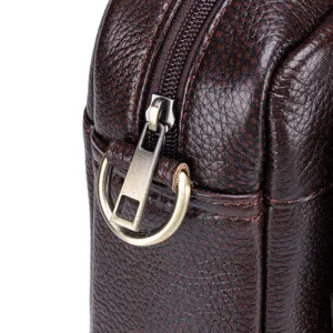 Close-up detail shot of dark brown leather mens business briefcase zipper and metal hardware
