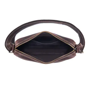 Close-up detail of vintage leather crossbody bag interior lining, showing zipper and inner pocket.