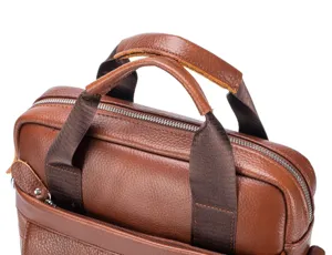 Brown leather briefcase handle detail, genuine cowhide business bag close up view.