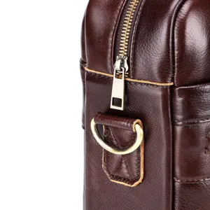 Close-up detail of genuine leather men bag zipper hardware, metal D-ring and stitching texture.