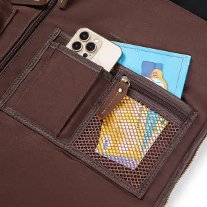 Travel suit bag interior detail, brown leather canvas storage organizer with pockets.