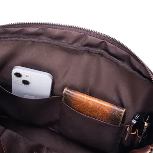 Dettaglio dell'interno della borsa da uomo in pelle con ampie tasche e pratici portapenne.