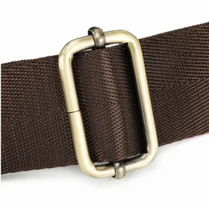 Close-up detail of dark brown bag strap with vintage brass adjustment slider buckle.