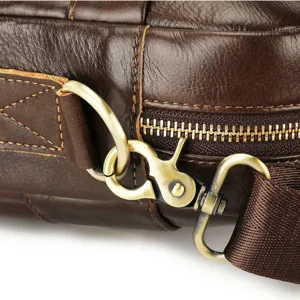 Closeup of men's leather briefcase detail featuring sturdy brass hardware and fine stitching.