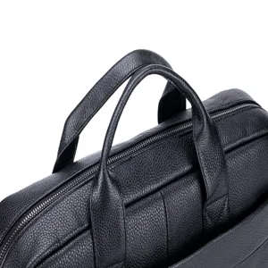 Close-up detail of the black leather briefcase handle, genuine cowhide texture and zipper.