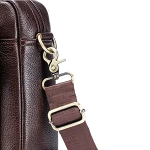 Genuine leather bag shoulder strap metal hardware detail close up showing durable buckle.