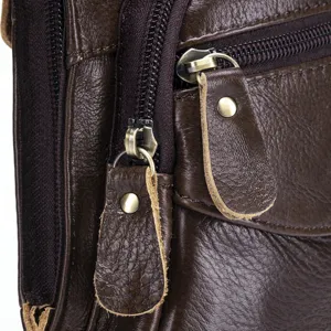 Gros plan détaillé du sac en cuir marron avec fermoirs métalliques et tirettes en cuir.