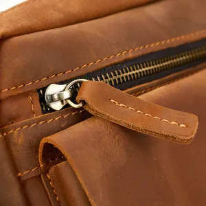 Close up detail shot of vintage crazy horse leather men messenger bag zipper and stitching.