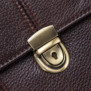 Close-up of premium brown leather men business briefcase with vintage metal lock clasp detail.