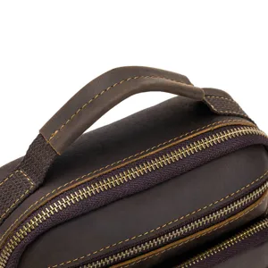 Close-up detail shot of vintage crazy horse leather bag handle and metal zippers.