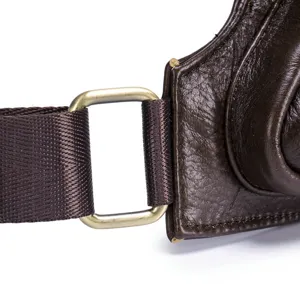 Gros plan sur la sangle de sac de poitrine en cuir véritable pour homme avec boucle métallique.