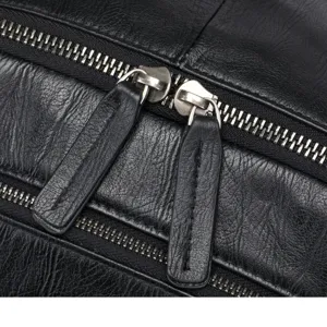 Close-up detail shot of black leather backpack showing durable zipper and metal puller design.