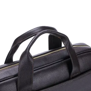 Close-up detail of dark brown genuine leather business briefcase handle and zipper.