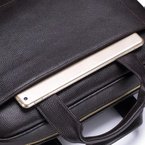 Close up detail of brown genuine leather business briefcase with textured cowhide surface.