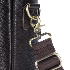 Close-up of genuine leather briefcase strap with bronze metal hardware and durable woven fabric.