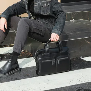 Detailed view of black leather business briefcase with dual front zippered pockets for men.