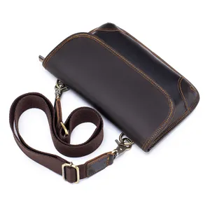 Detailed view of men's leather crossbody bag with adjustable strap and metal hardware.