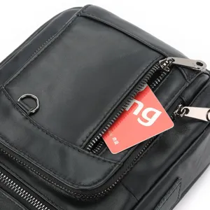 Close up detail of black genuine leather men messenger bag front zipper pocket and card slot.