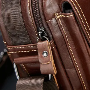Close-up detail of genuine leather men messenger bag zipper and stitching craftsmanship.